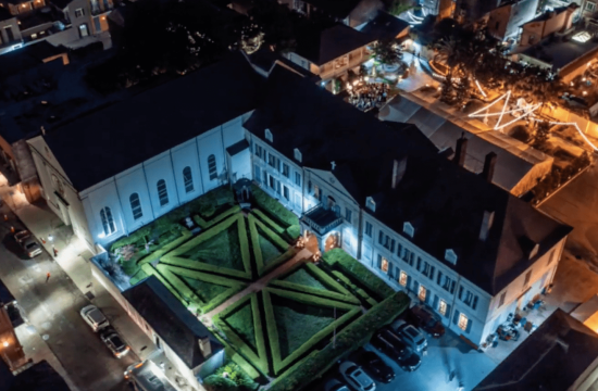 aerial photo of a building in the french quarter with a garden in front at night time