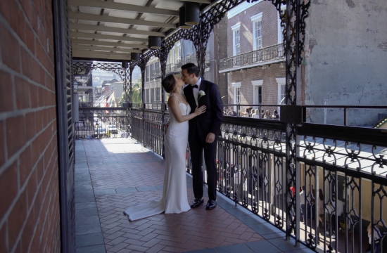 bride and groom kissing on balcony